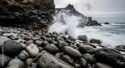 Ocean waves crashing on rocky coastline with dark stones