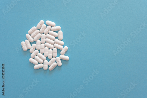 Tabletten or pillen in white package on the blue background with place for text.
