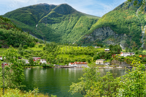 Tranquil Flam fjord landscape with charming village and imposing peaks.