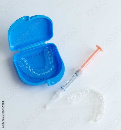 Dental whitening trays and gel applicator on white background