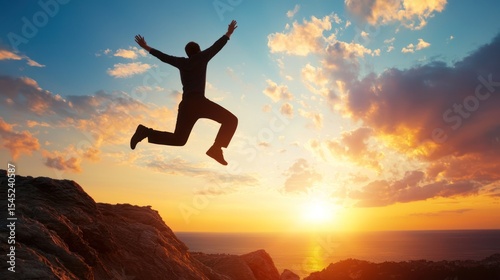 Wallpaper Mural A silhouette of a person jumping in the air with a mountainous landscape and a sunset in the background. Torontodigital.ca