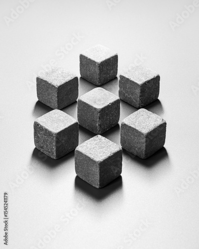 Minimalist abstract still life of 3D shape composed of stone cubes in harsh light with deep shadows