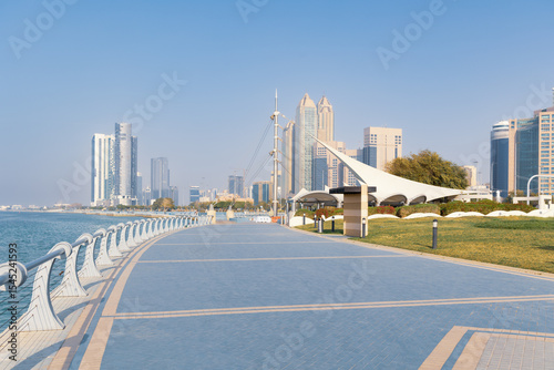 Empty Corniche Street sea view pedestrian path with modern skyscrapers on bright sunny day, Abu Dhabi