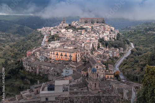 Ancient hilltop town buildings, cathedral and tiled roofs on cloudy day, Ragusa Ibla, Sicily, Italy