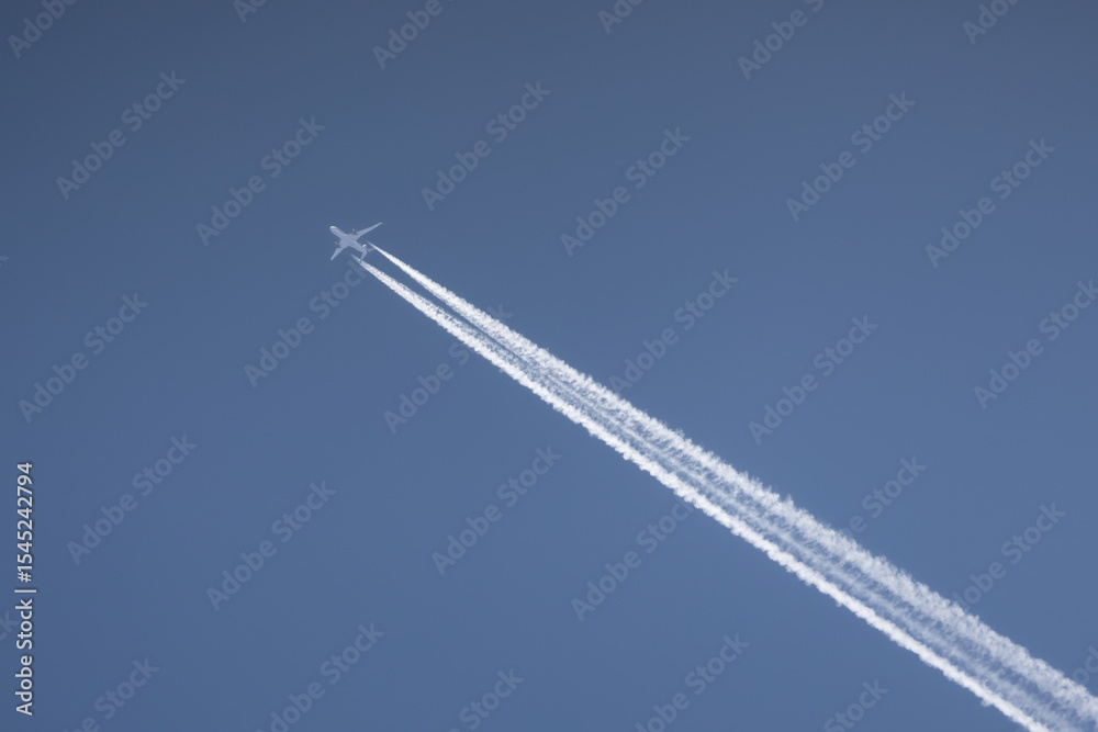 Commercial two engines jet airliner flies high in clear sky leaving bright white trace Commercial two engines jet airliner flies high in clear sky leaving bright white trace