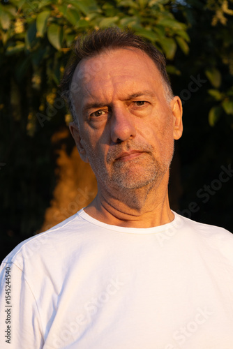 Man between 55 and 60 years old posing for the camera. Adult man wearing modern clothes.