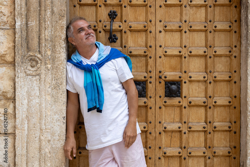 Man between 55 and 60 years old posing for the camera. Adult man wearing modern clothes.