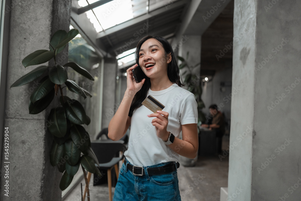 Fototapeta premium Happy asian woman holding credit card and using smartphone for online shopping