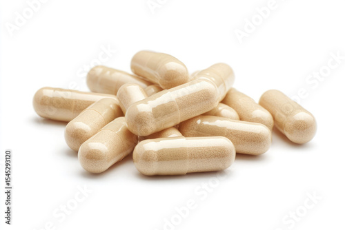 Beige capsules and single tablet on white background