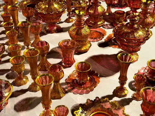 This high-angle, close-up shot beautifully captures a vibrant and extensive collection of antique ruby red and cranberry glass objects. Each piece, from elegant vases and ornate goblets to intricate