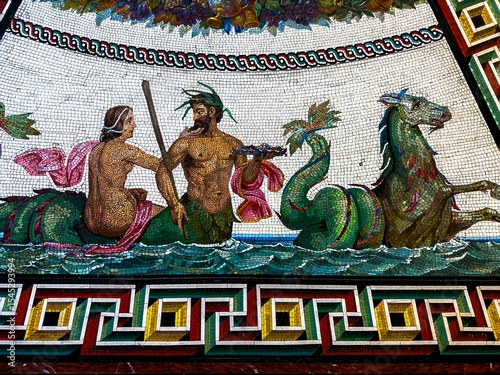 This detailed eye-level shot captures a vibrant ancient Roman mosaic, showcasing a mythological scene with intricate tesserae. The central figures include a merman, holding a trident, and a mermaid