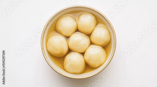 Rasgulla dipped in sugary syrup in white background