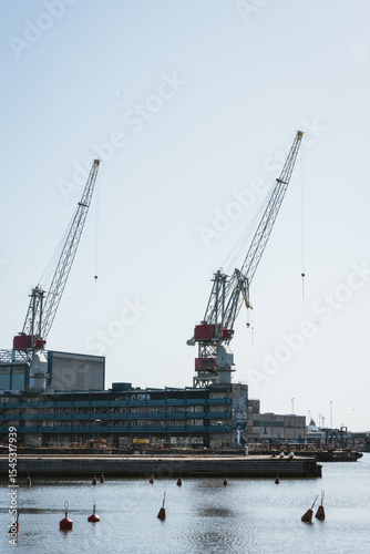 Large harbor cranes standing tall at a shipyard in Helsinki, Finland. Industrial maritime scene on a sunny day, capturing the essence of shipbuilding and infrastructure. photo