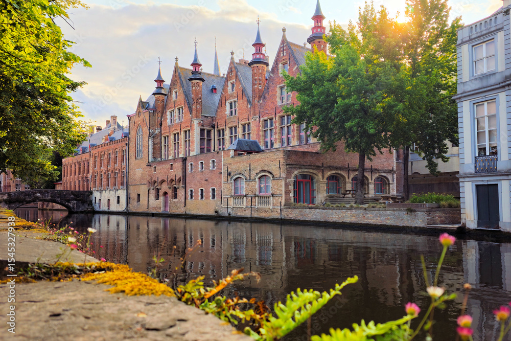 Obraz premium Medieval buildings lining the picturesque canals of Bruges, Belgium at sunset