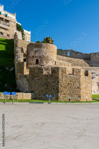 Scenic views of Tangier's seafront and old medina walls on a sunny day, showing a mix of coastal charm, public spaces, and historic Moroccan architecture
