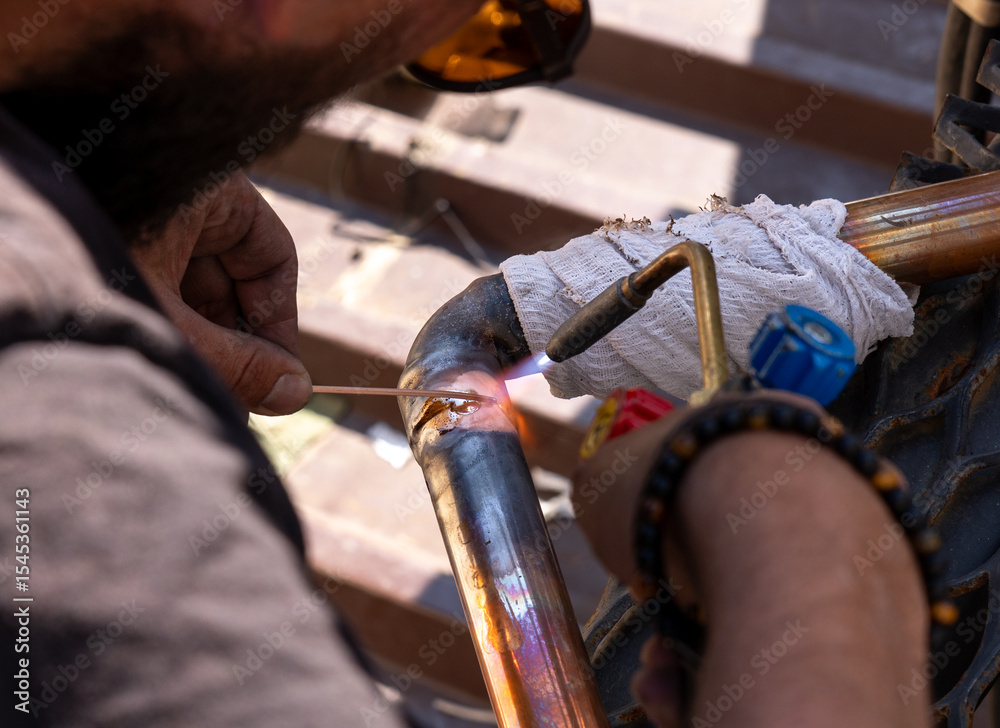 Obraz premium worker soldering copper pipes