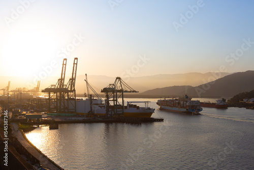 Movement in the port of Santos during sunset, with ships entering