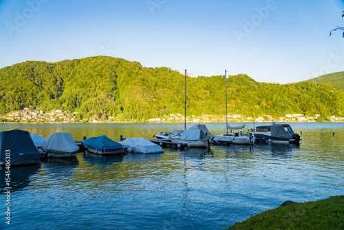 View of boats moored on Lake Lugano, village of Caslano. Switzerland
