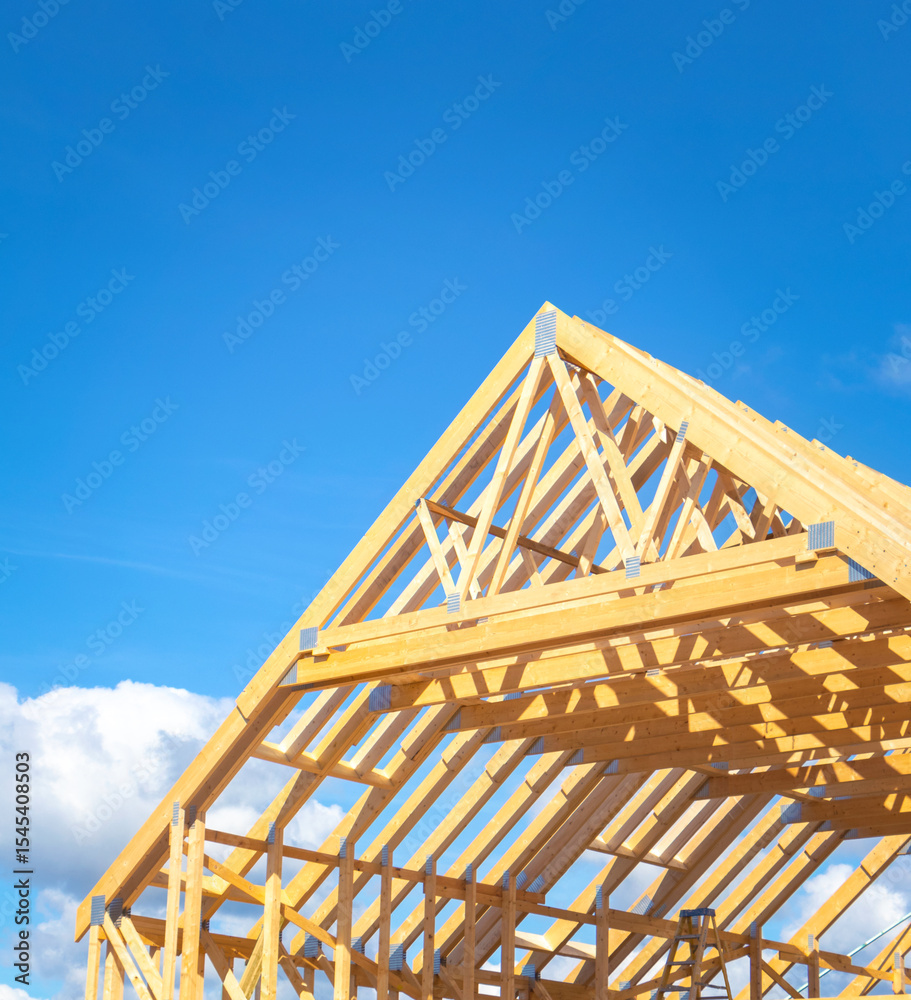 Obraz premium Partly assembled roof frame using stubbed eaves trusses comprised of a series of sloped wooden, structural members. Similar to a timber rafter construction for attic space. Plenty of empty copy space.