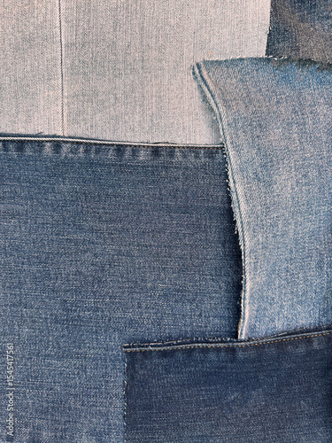 Pieces of material are arranged in attractive fashion as patchwork. The pieces are flat, ironed, clean and cut. Shapes are irregular and colors are muted tones of blue, from very light to deep navy.