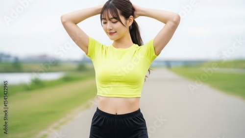 日本人女性が屋外でリラックスしてストレッチをする