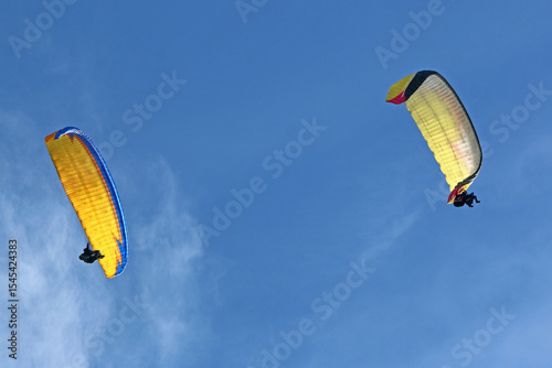 Paragliders flying in a blue sky	