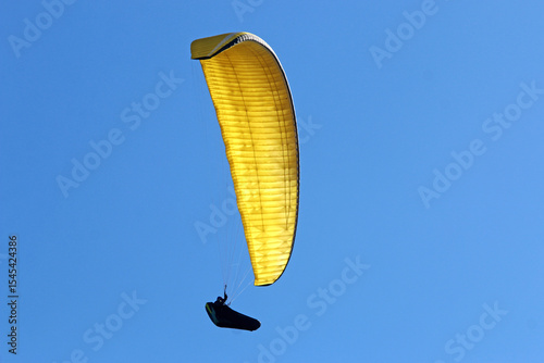 Paraglider flying in a blue sky	