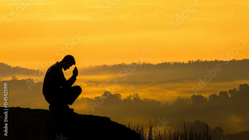 A man’s silhouette kneels in prayer atop a mountain at sunrise. Golden light fills the sky, mist veils the valley below. The scene evokes deep solitude, surrender, and spiritual reflection.