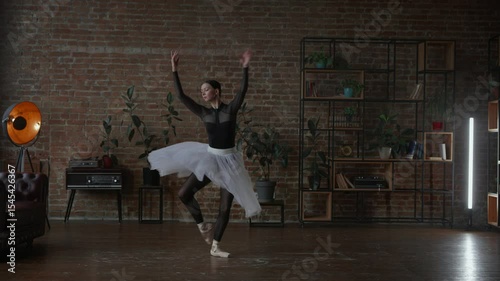 An elegant ballet performance in a modern studio showcases artistry and grace in every move