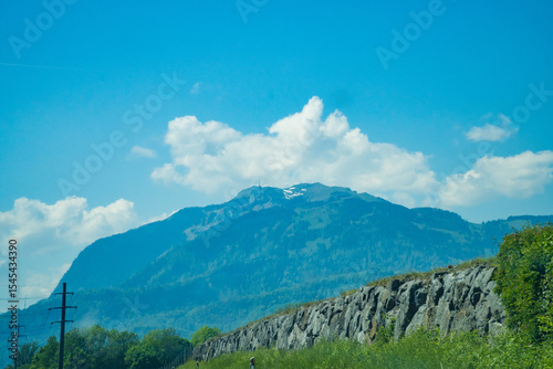 Idyllic landscape in the Alps with fresh green meadows and mountain peaks.