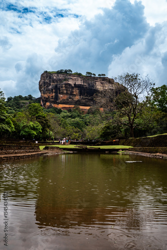 Sigiriya Rock Fortress under cloudy skies, iconic ancient site in Sri Lanka. Travel and history.