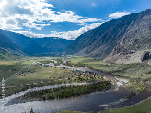 Summer landscape in the Chulyshman mountain valley. Winding mountain river, green alpine meadows and beautiful mountains.