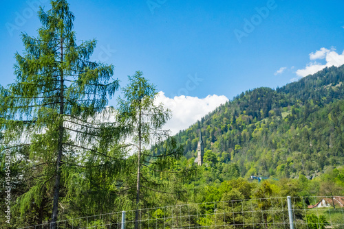 Idyllic landscape in the Alps with fresh green meadows and mountain peaks.