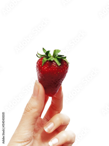 Woman holding a fresh strawberry with fingers