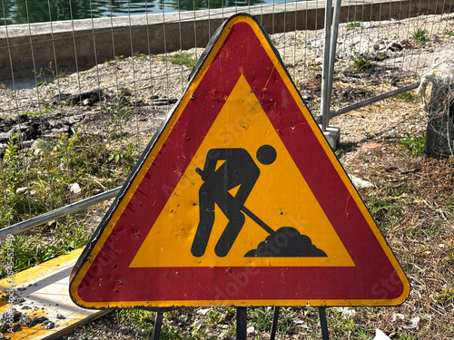 Work in progress sign positioned at the entrance of a construction site, indicating ongoing roadwork or building activities.
