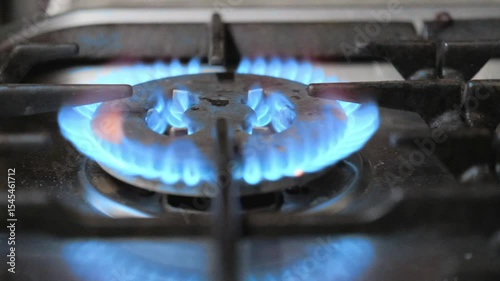 Close-up of the gas ignites and burns with a blue flame when the home gas stove is turned on. Concept natural gas is burned in a home stove.