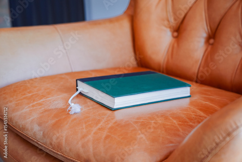 Hardbound book on leather reading chair