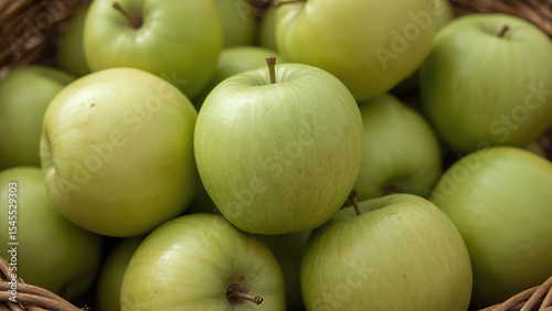 Close-up of a wicker basket overflowing with ripe green apples. Perfect for food and agriculture-themed designs and concepts. Vibrant and fresh.