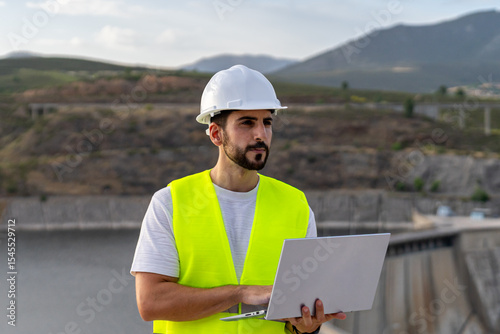Engineer supervising water resources and renewable energy with laptop
