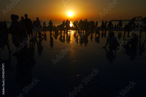 a beautiful sunset in Zadar with many people playing with reflections in summer, Croatia