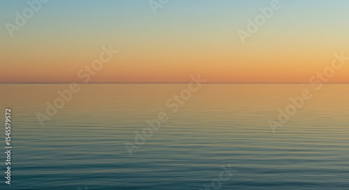 A serene sunset over a calm body of water.  Soft colors blend seamlessly
