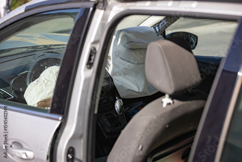 Crashed car with damaged front and opened airbags