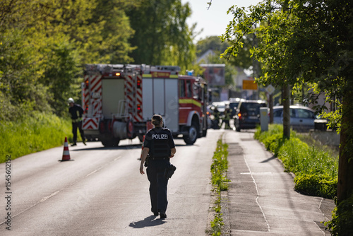 German Police woman walking on road towards car accident