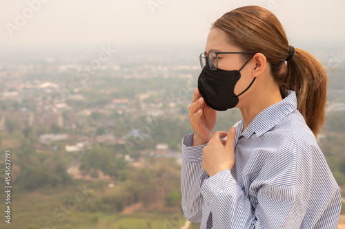 Asian businesswoman coughing becaused of allergy from Bad air pollution (PM2.5). PM2.5 levels meaning the air quality posed a health hazard.