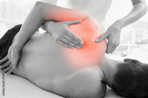 Rear view of injured man having massage