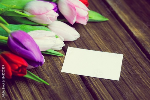 Fototapeta Naklejka Na Ścianę i Meble -  Flat design is showing multicolored tulip cluster on wooden slatted table with blank white card