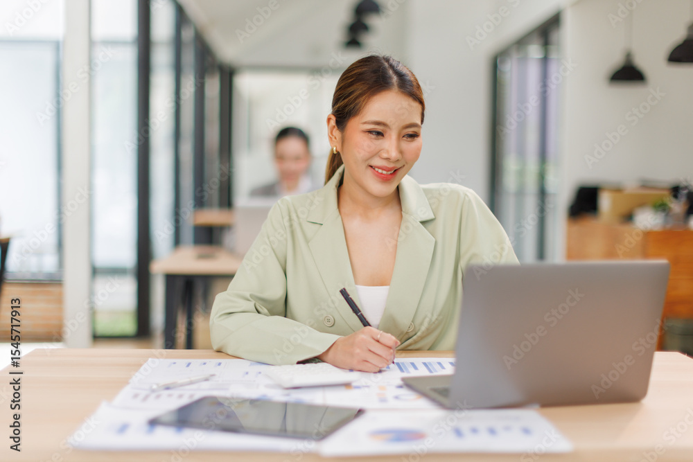 Shot of a asian business female working on laptop computer in her workstation.Portrait of Business people employee freelance online marketing e-commerce telemarketing concept. Shot of a asian business female working on laptop computer in her workstation.Portrait of Business people employee freelance online marketing e-commerce telemarketing concept.