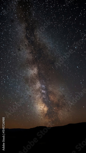Galaxy background with Milky Way arching over majestic mountain range, perfect for astronomy, nature, space, travel designs, and backgrounds.