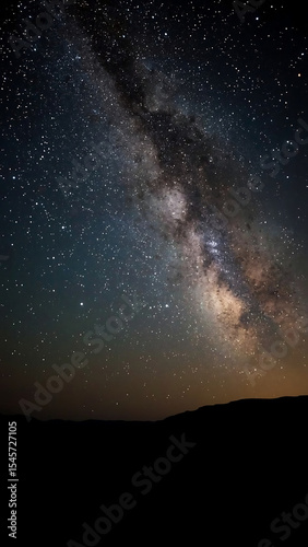 Galaxy background with Milky Way arching over majestic mountain range, perfect for astronomy, nature, space, travel designs, and backgrounds.