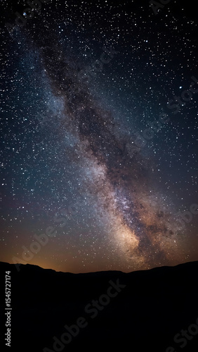 Galaxy background with Milky Way arching over majestic mountain range, perfect for astronomy, nature, space, travel designs, and backgrounds.